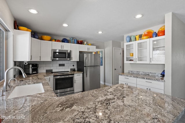 2282 W Rapallo Way, Tucson, AZ 85741 - kitchen featuring appliances with stainless steel finishes, a sink, light stone counters, glass insert cabinets, and white cabinetry