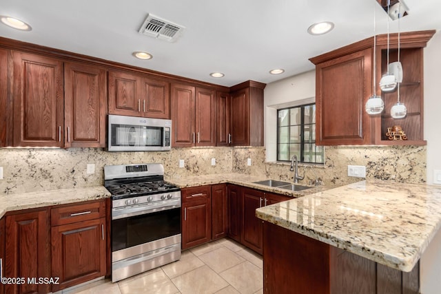 kitchen featuring stainless steel appliances, a sink, a peninsula, decorative light fixtures, and backsplash