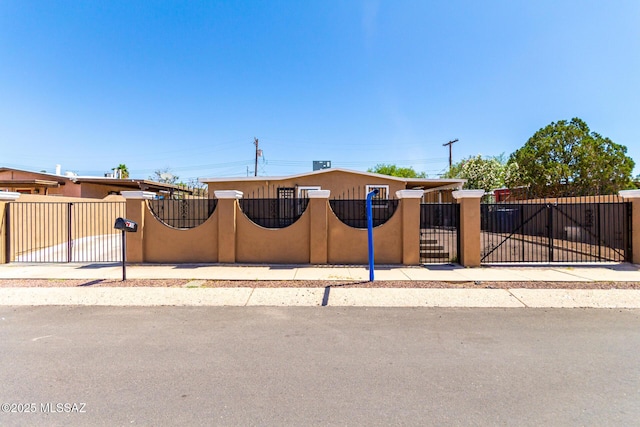 view of front of home with a fenced front yard and a gate
