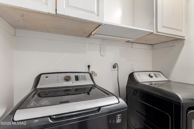 washroom with cabinet space and washer and dryer