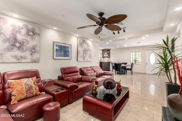 living area featuring a tray ceiling, a ceiling fan, and recessed lighting