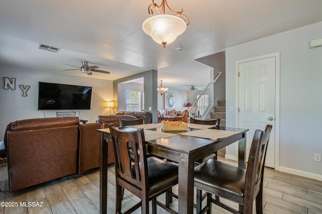 14570 S Sumac Dr, Sahuarita, AZ 85629 - dining space with a ceiling fan, stairs, light wood-style floors, baseboards, and a chandelier