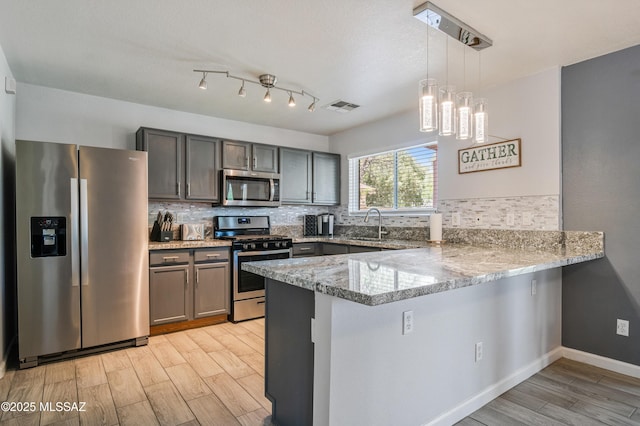 14570 S Sumac Dr, Sahuarita, AZ 85629 - kitchen featuring stainless steel appliances, a peninsula, light wood-type flooring, and light stone countertops