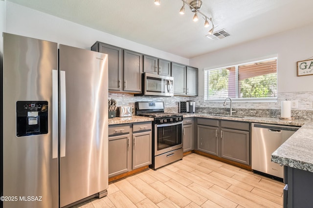 14570 S Sumac Dr, Sahuarita, AZ 85629 - kitchen with appliances with stainless steel finishes, a sink, decorative backsplash, light wood-type flooring, and track lighting
