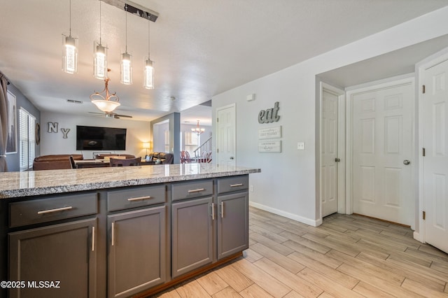 14570 S Sumac Dr, Sahuarita, AZ 85629 - kitchen with gray cabinetry, ceiling fan, light wood finished floors, decorative light fixtures, and open floor plan