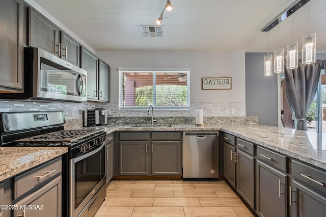 14570 S Sumac Dr, Sahuarita, AZ 85629 - kitchen with appliances with stainless steel finishes, a sink, backsplash, and light stone countertops