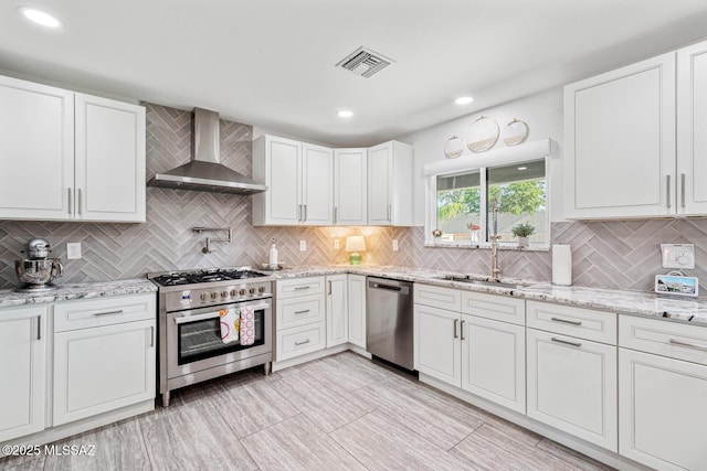 3454 E Calle Del Prado, Tucson, AZ 85716 - kitchen featuring appliances with stainless steel finishes, wall chimney exhaust hood, a sink, decorative backsplash, and white cabinets
