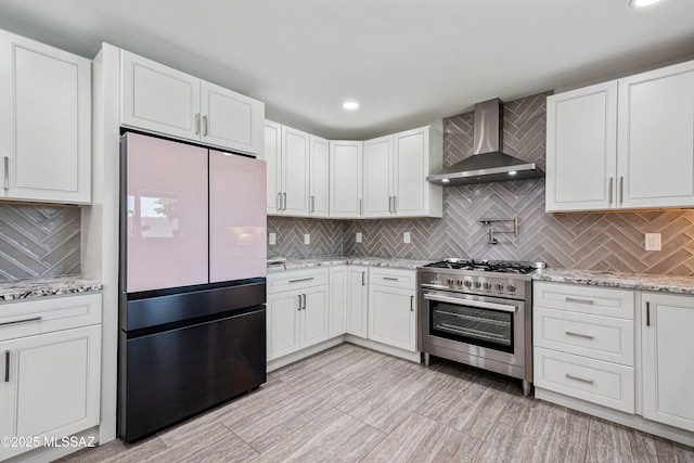 3454 E Calle Del Prado, Tucson, AZ 85716 - kitchen featuring wall chimney exhaust hood, freestanding refrigerator, high end range, decorative backsplash, and recessed lighting