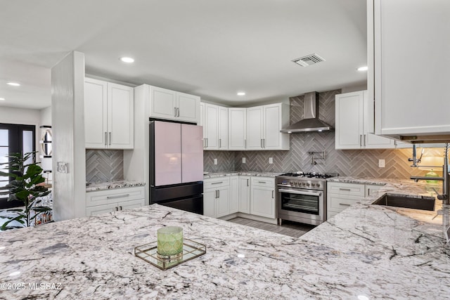 3454 E Calle Del Prado, Tucson, AZ 85716 - kitchen with freestanding refrigerator, wall chimney exhaust hood, high end stainless steel range, backsplash, and recessed lighting
