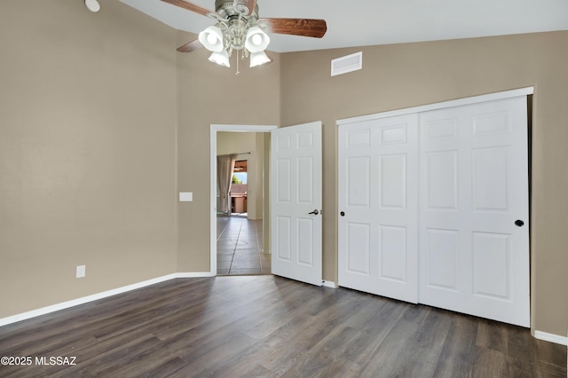 14024 E Fairway Bluff Ct, Vail, AZ 85641 - unfurnished bedroom featuring baseboards, dark wood-type flooring, a closet, a high ceiling, and ceiling fan