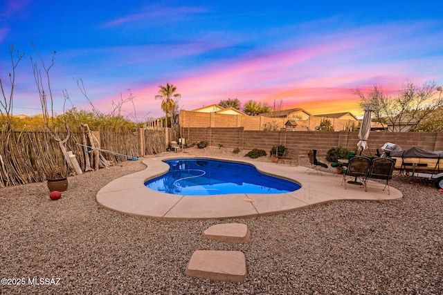 14234 E Placita Niebla, Tucson, AZ 85747 - pool at dusk featuring a patio area and a fenced backyard