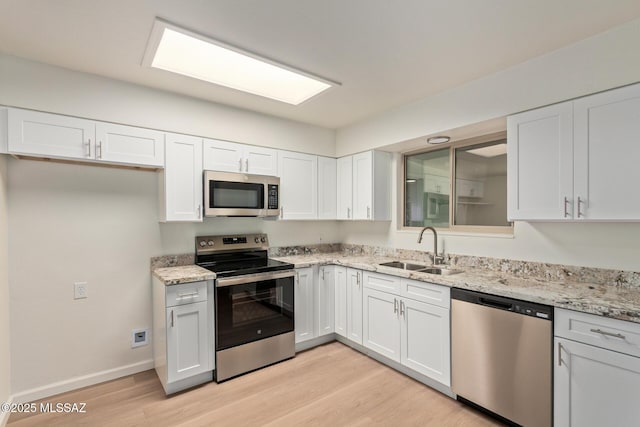 1540 N Calle Valencia, Oracle, AZ 85623 - kitchen featuring stainless steel appliances, a sink, light wood finished floors, and white cabinets
