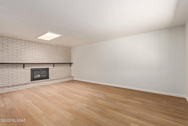 1540 N Calle Valencia, Oracle, AZ 85623 - unfurnished living room featuring a brick fireplace, wood finished floors, and baseboards