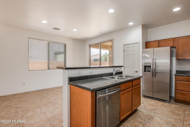 6837 W Leeward Cove Way, Tucson, AZ 85757 - kitchen featuring stainless steel appliances, brown cabinets, dark countertops, recessed lighting, and a kitchen island with sink