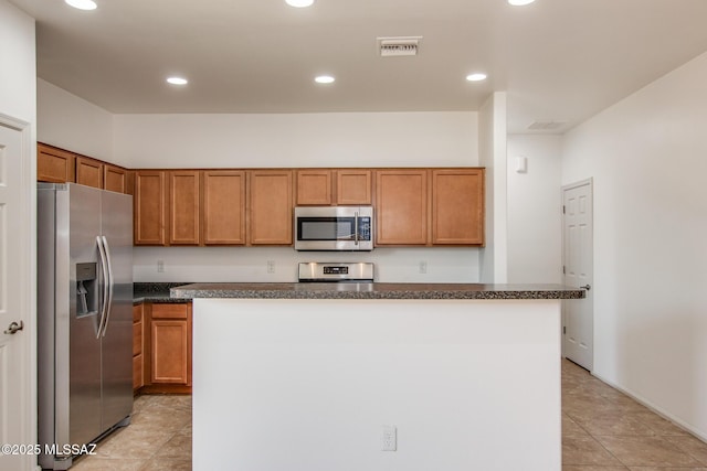 6837 W Leeward Cove Way, Tucson, AZ 85757 - kitchen featuring appliances with stainless steel finishes, a center island, brown cabinets, recessed lighting, and light tile patterned flooring