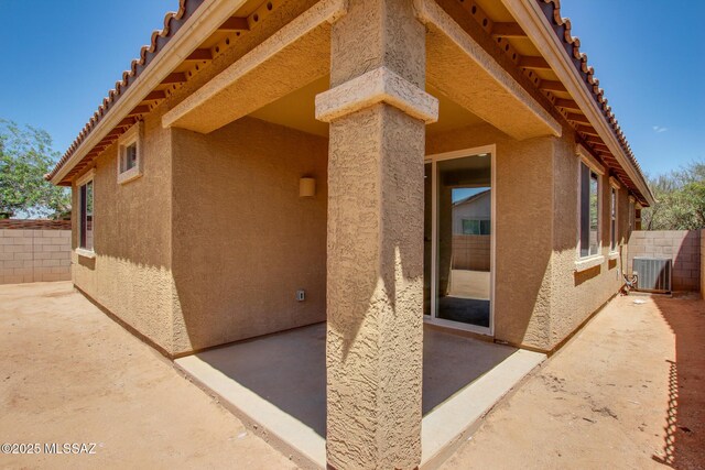 6837 W Leeward Cove Way, Tucson, AZ 85757 - view of exterior entry with a patio area, stucco siding, and fence