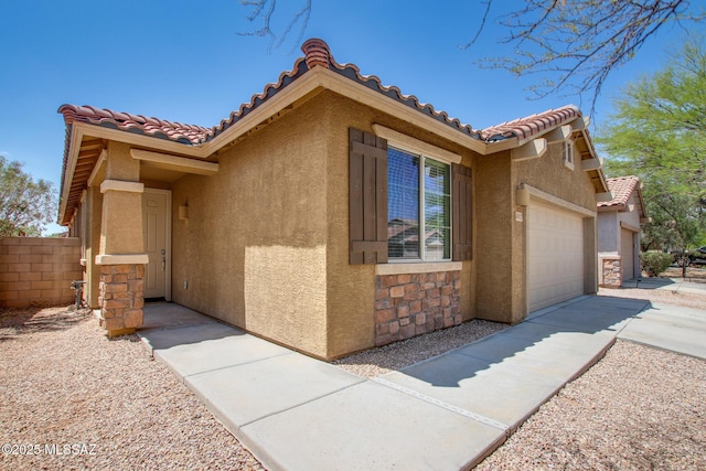 6837 W Leeward Cove Way, Tucson, AZ 85757 - view of front facade featuring stucco siding, a garage, a tiled roof, and stone siding