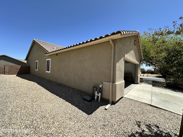2108 W Moon Milk St, Benson, AZ 85602 - view of side of property featuring stucco siding, fence, a tile roof, and a patio