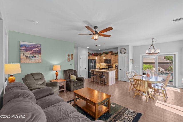 2108 W Moon Milk St, Benson, AZ 85602 - living area with wood finished floors, a ceiling fan, a chandelier, and recessed lighting
