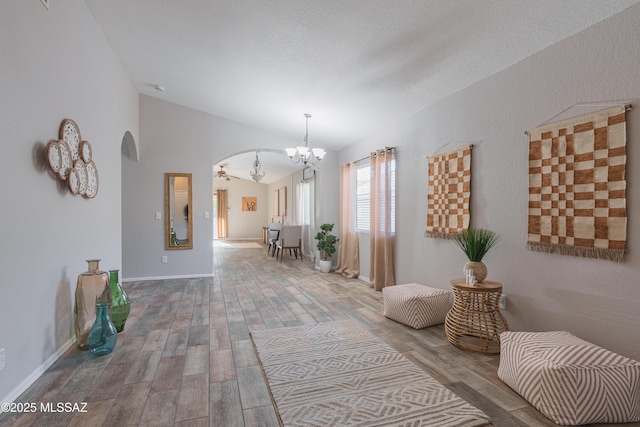 9536 N Scarlet Tanager Ln, Tucson, AZ 85742 - hall with arched walkways, a chandelier, lofted ceiling, wood finished floors, and baseboards