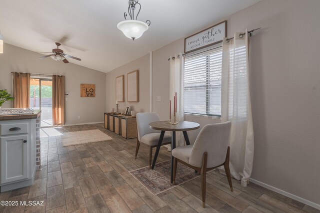 9536 N Scarlet Tanager Ln, Tucson, AZ 85742 - dining space with ceiling fan, dark wood-type flooring, lofted ceiling, and baseboards