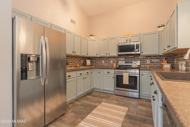 9536 N Scarlet Tanager Ln, Tucson, AZ 85742 - kitchen with appliances with stainless steel finishes, dark wood finished floors, decorative backsplash, and a sink
