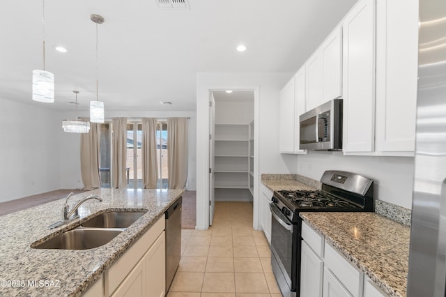 kitchen with appliances with stainless steel finishes, a sink, pendant lighting, recessed lighting, and white cabinetry