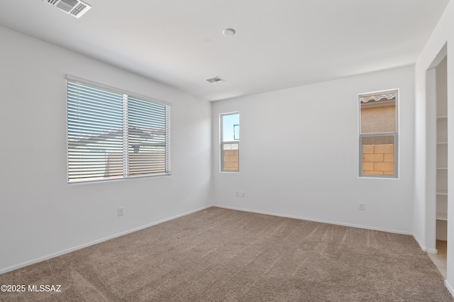 spare room with light colored carpet and baseboards