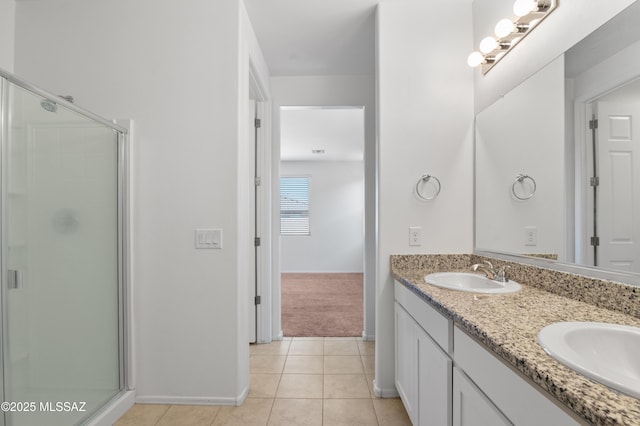 full bathroom featuring a stall shower, tile patterned flooring, double vanity, and baseboards