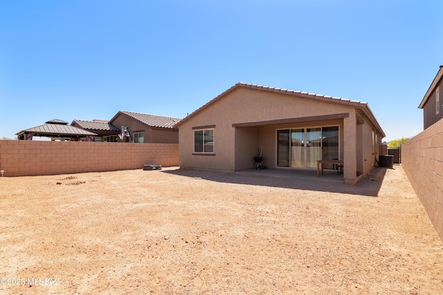 back of property featuring a fenced backyard, stucco siding, a patio, and a tile roof