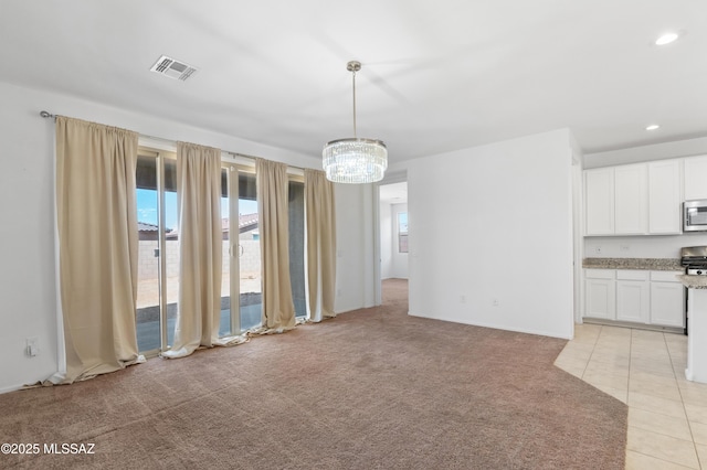 unfurnished dining area featuring a chandelier, light carpet, light tile patterned flooring, and recessed lighting