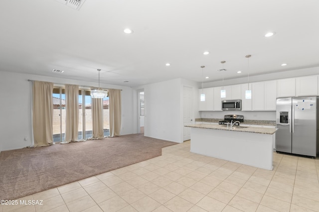 kitchen with stainless steel appliances, light carpet, recessed lighting, open floor plan, and white cabinetry