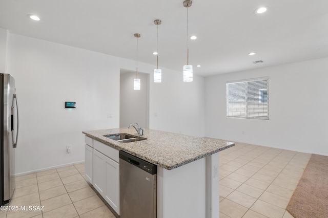 kitchen with a sink, stainless steel appliances, light tile patterned flooring, white cabinetry, and light stone countertops