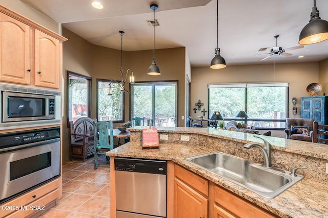 124 Circulo Vespucci, Tubac, AZ 85646 - kitchen with stainless steel appliances, a sink, light brown cabinets, light tile patterned flooring, and decorative light fixtures