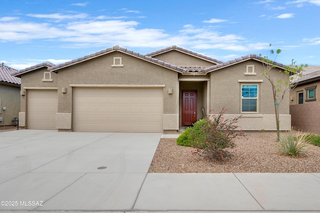 12513 Denton Way, Marana, AZ 85653 - view of front of house featuring an attached garage, stucco siding, concrete driveway, and a tiled roof