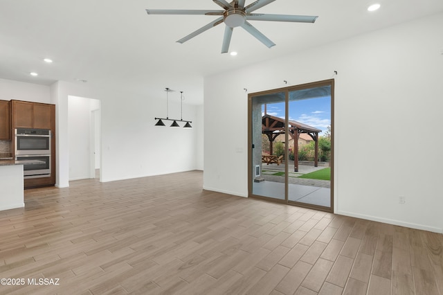 12513 Denton Way, Marana, AZ 85653 - unfurnished living room with light wood-type flooring, a ceiling fan, recessed lighting, and baseboards
