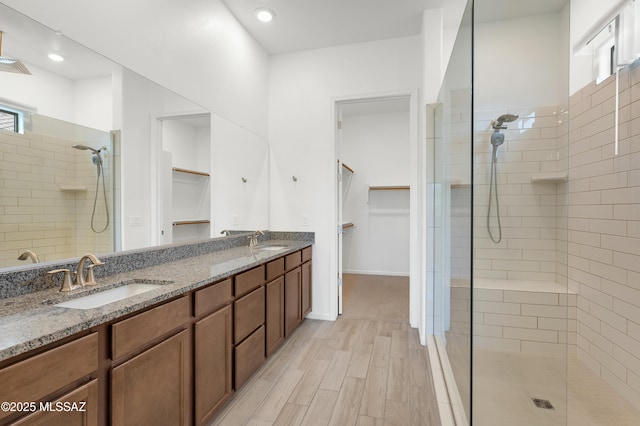 12513 Denton Way, Marana, AZ 85653 - bathroom featuring tiled shower, double vanity, a spacious closet, wood finished floors, and recessed lighting