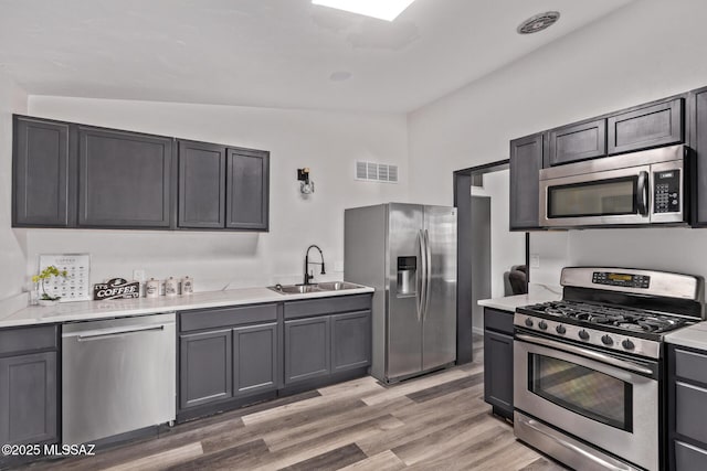 1025 E Windsor St, Tucson, AZ 85719 - kitchen featuring stainless steel appliances, a sink, and light wood-style flooring