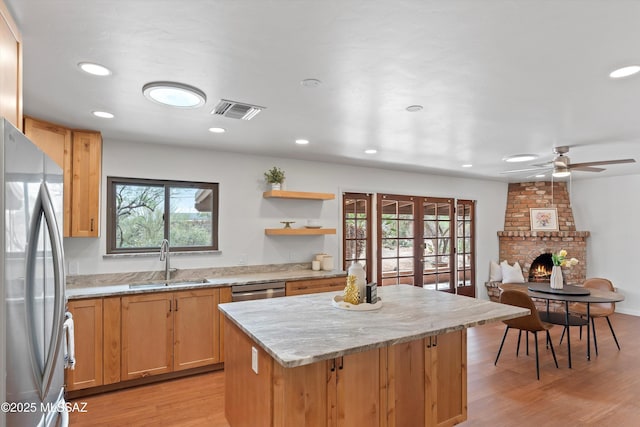 1241 W Cananea Cir, Tucson, AZ 85704 - kitchen with stainless steel appliances, a sink, a kitchen island, light wood-style flooring, and recessed lighting