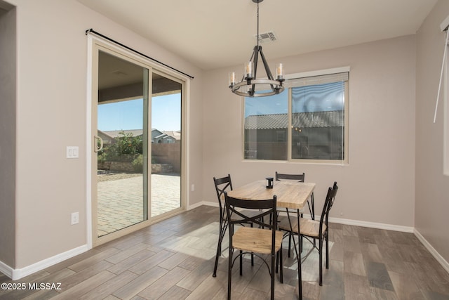 8040 N Desert Gum Dr, Tucson, AZ 85741 - dining area with a chandelier, wood finished floors, and baseboards