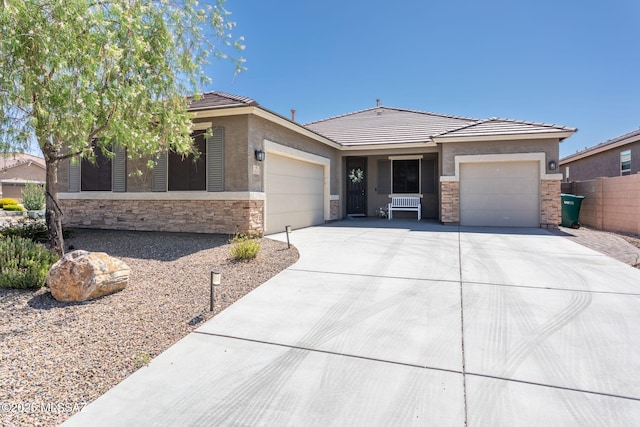8040 N Desert Gum Dr, Tucson, AZ 85741 - view of front of home with an attached garage, stone siding, driveway, and a tile roof