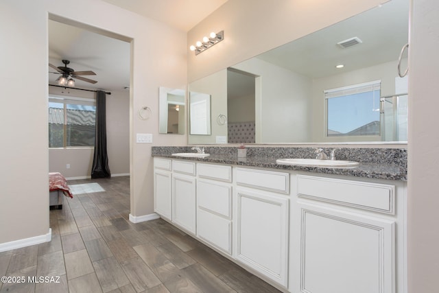 8040 N Desert Gum Dr, Tucson, AZ 85741 - full bath featuring double vanity, a ceiling fan, wood finished floors, and baseboards
