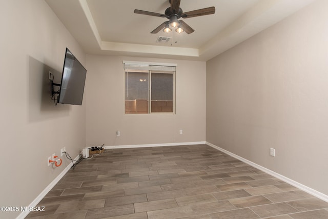 8040 N Desert Gum Dr, Tucson, AZ 85741 - empty room featuring ceiling fan, a raised ceiling, wood finished floors, and baseboards
