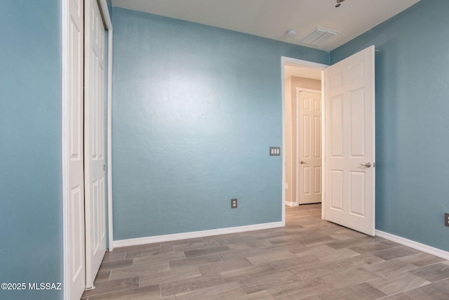 8040 N Desert Gum Dr, Tucson, AZ 85741 - unfurnished bedroom with wood finished floors, baseboards, and a closet