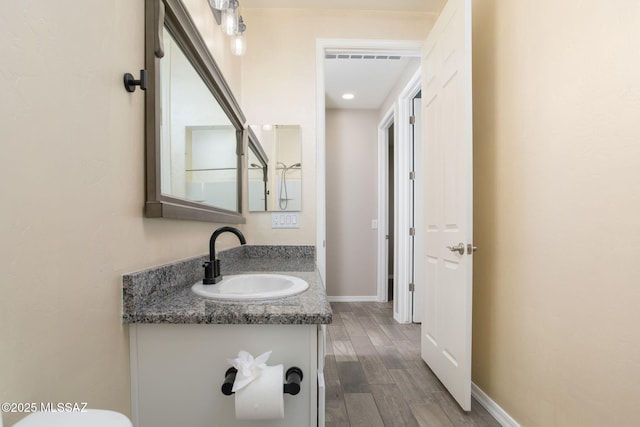 8040 N Desert Gum Dr, Tucson, AZ 85741 - half bathroom with wood finished floors, vanity, and baseboards