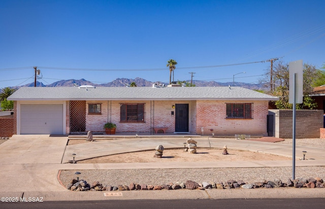 5449 E Rosewood St, Tucson, AZ 85711 - ranch-style home with a mountain view, a garage, driveway, and brick siding