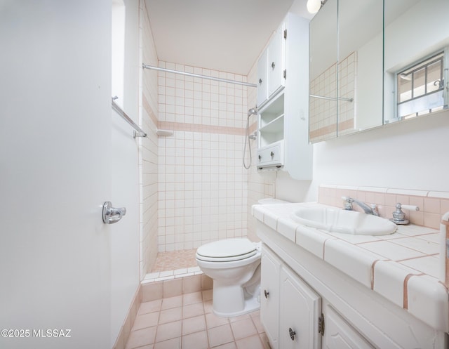 5449 E Rosewood St, Tucson, AZ 85711 - full bathroom featuring a tile shower, toilet, vanity, and tile patterned flooring