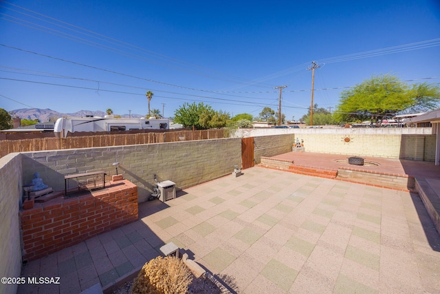 5449 E Rosewood St, Tucson, AZ 85711 - fenced backyard with a patio, a mountain view, and a fire pit