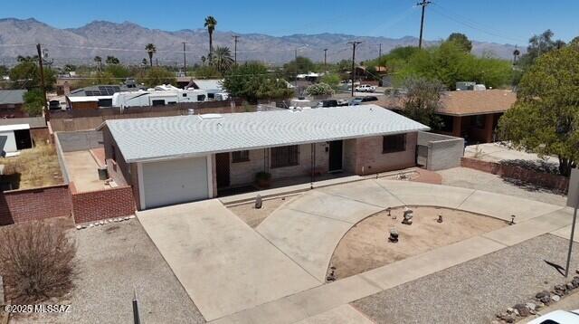 5449 E Rosewood St, Tucson, AZ 85711 - ranch-style house with a mountain view, an attached garage, and driveway