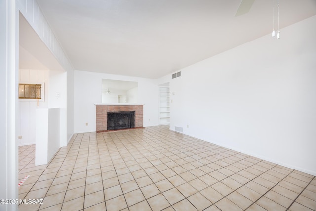 5449 E Rosewood St, Tucson, AZ 85711 - unfurnished living room with light tile patterned floors, a fireplace, built in shelves, and ceiling fan
